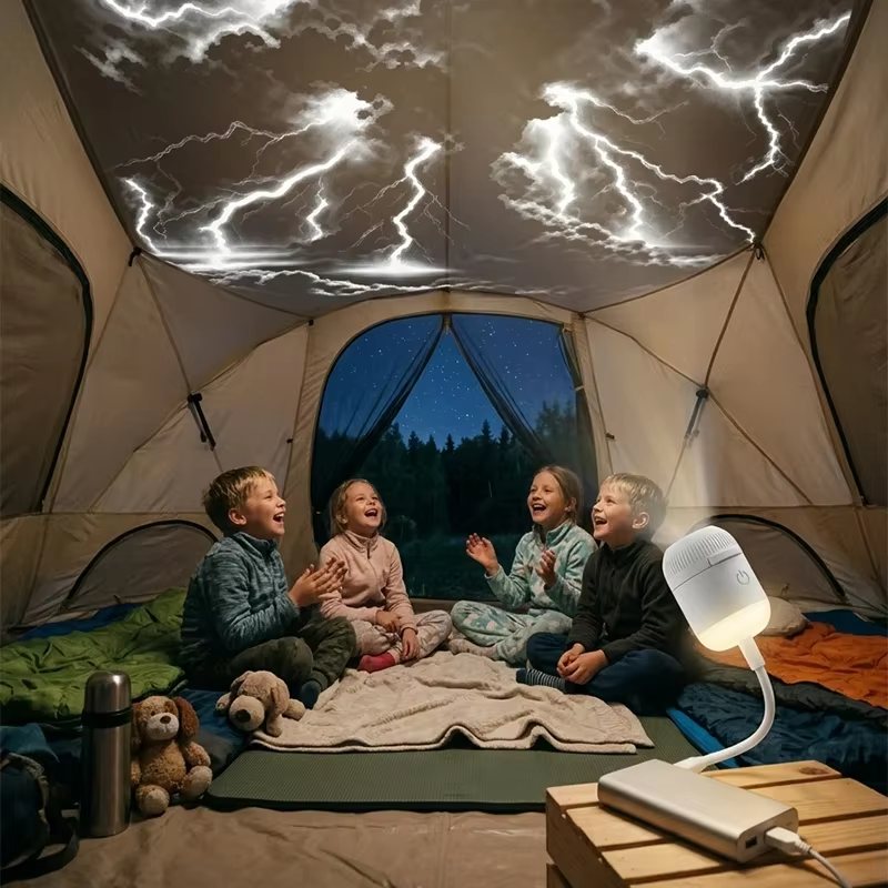 Kids camping in a tent at night under a starry sky projected by the Galaxy Star Projector