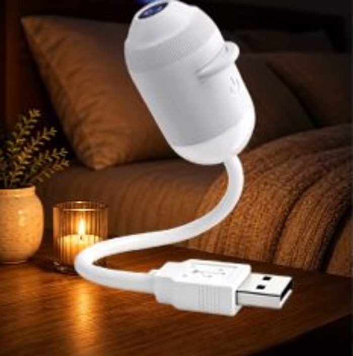 Galaxy Star Projector on a nightstand next to a candle